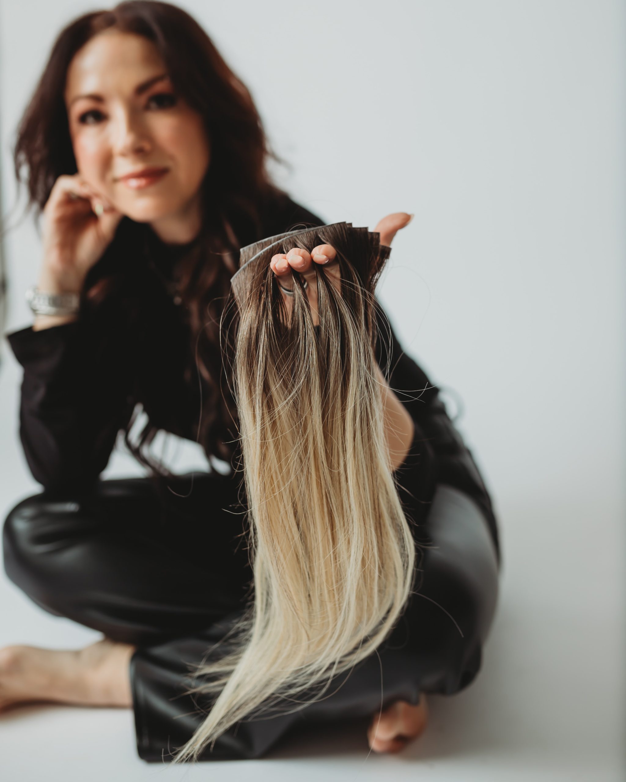 amber mayo holding hair extensions at her studio in Gainesville, VA
